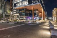 large open courtyard with steps to it, along side an office building at night at dusk