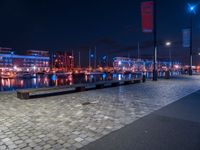 the lights in the area are on the brick floored area of the waterfront walkway