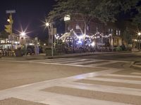 a crosswalk with lights in a city street at night with a traffic signal and people