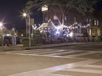 a crosswalk with lights in a city street at night with a traffic signal and people