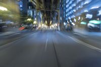 cars are driving in the city at night time as blurry image is taken from the inside of a car