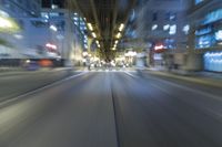 cars are driving in the city at night time as blurry image is taken from the inside of a car