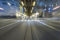 cars are driving in the city at night time as blurry image is taken from the inside of a car