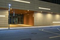 the entrance to a building with illuminated lights on it at night time at night, in the city