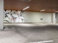 a parking spot with painted flowers on the wall on the ceiling and white lines on the floor