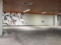 a parking spot with painted flowers on the wall on the ceiling and white lines on the floor