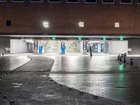 there is an empty parking garage at night time on the street where cars are parked