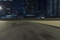 a motion blur photograph of a highway in a city at night with a car going along the right bank