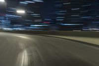 a motion blur photograph of a highway in a city at night with a car going along the right bank