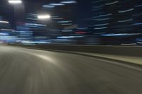 a motion blur photograph of a highway in a city at night with a car going along the right bank