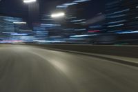 a motion blur photograph of a highway in a city at night with a car going along the right bank