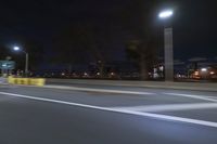 a truck is driving down a highway with lights shining on it at night behind him are a street lamp