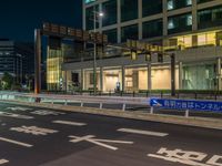 an image of outside of the night time building with the lights turned on and the streets empty