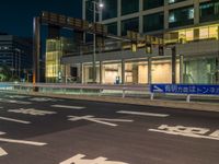 an image of outside of the night time building with the lights turned on and the streets empty