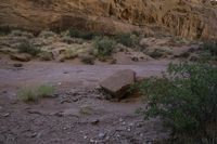 a mountain range near a river with some boulders on it at night time with mountains in the background