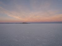 people skiing down the snow covered ground in the middle of nowhere or frozen lake ice