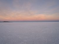 people skiing down the snow covered ground in the middle of nowhere or frozen lake ice