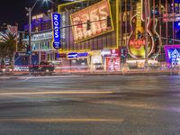 a city with neon signs lit up at night time that says rock n'roll