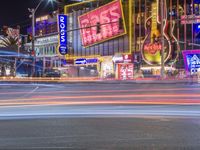 a city with neon signs lit up at night time that says rock n'roll