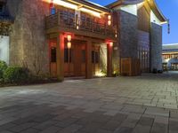 a building with some lights in front of it in a courtyard area and landscaping at night