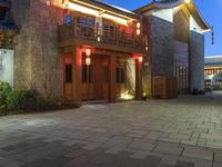 a building with some lights in front of it in a courtyard area and landscaping at night