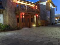 a building with some lights in front of it in a courtyard area and landscaping at night