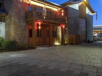 a building with some lights in front of it in a courtyard area and landscaping at night