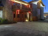 a building with some lights in front of it in a courtyard area and landscaping at night