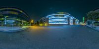 an image of a street at night from a fish eye lens as seen in a 360 - view mirror