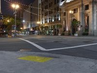 a view of a city street at night with lights on and an open fire hydrant