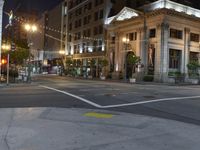 a view of a city street at night with lights on and an open fire hydrant