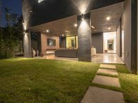 a large modern house lit up at night by leds and stone steps and outdoor furniture