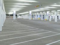 a parking lot filled with lots of white space, with concrete floors and white pillars