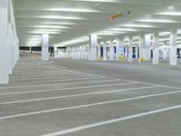 a parking lot filled with lots of white space, with concrete floors and white pillars