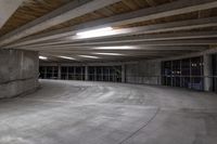 an empty parking garage has a lot of concrete walls and beams above the ceiling on top