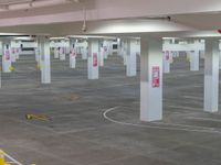 a large empty parking garage with yellow caution signs on it's walls and floor
