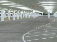 a parking garage with multiple spots on the ground, and several empty cars lined up