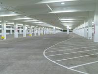 a parking garage with multiple spots on the ground, and several empty cars lined up