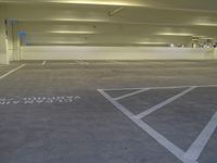 a white parking lot with some lights on the ceiling and a yellow wall to the right