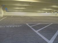 a white parking lot with some lights on the ceiling and a yellow wall to the right