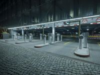 a parking lot with several signs lit up in the dark at night time's