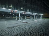 a parking lot with several signs lit up in the dark at night time's