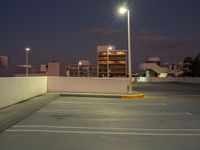 this is the image of a parking lot with buildings in the background at night time