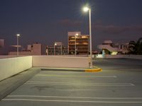 this is the image of a parking lot with buildings in the background at night time