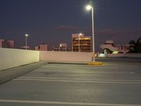 this is the image of a parking lot with buildings in the background at night time