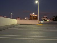 this is the image of a parking lot with buildings in the background at night time