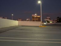 this is the image of a parking lot with buildings in the background at night time