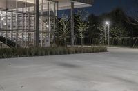 a parking lot with parking lots at night and lights on it at night, and some trees in the background