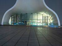 there is a circular building with a roof on it's side, with windows, and a bench outside the window