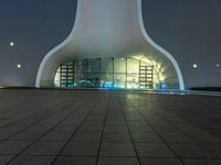 a building with a tall dome shaped structure with several lights on top of it in front of a night sky